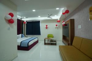 een slaapkamer met een bed en een bank en rode ballonnen bij Hotel Raison Inn Bechraji in Kalri