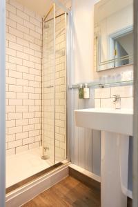 uma casa de banho com um lavatório e um chuveiro em Rashleigh Arms em St Austell
