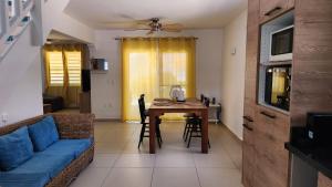 ein Wohnzimmer mit einem Tisch und einem blauen Sofa in der Unterkunft Ocean Teal Villa Marazul in Westpunt
