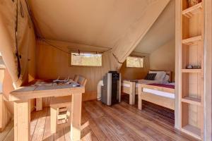 a room with a bed and a desk in a tent at Tent #4-Luxury Camping Tent near Johnson City, Texas in Johnson City