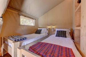 ein Schlafzimmer mit 2 Betten in einem winzigen Haus in der Unterkunft 12 Fires Luxury Glamping with AC #4 in Johnson City