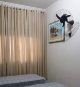 1 dormitorio con ventilador en la pared y 1 cama en Casa Inteira Próxima ao Centro / 4 Suítes. en Londrina