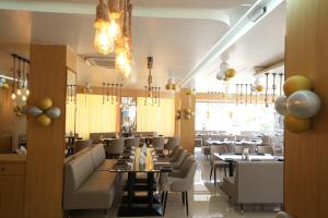 a restaurant with tables and chairs and a dining room at Hotel Raison Inn Bechraji in Kalri
