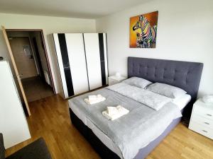 una camera da letto con un letto e due asciugamani di THE BIG SPACE - Apartmaji PANONIA a Moravske Toplice