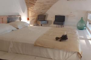 a bedroom with a large white bed with two monitors at La Cantina: cosy stylish vaults in Villalfonsina