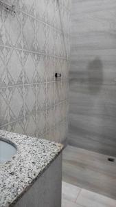 a bathroom with a sink and a shower at Casa Inteira Próxima ao Centro / 4 Suítes. in Londrina