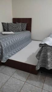 ein großes Bett in einem weißen Zimmer mit in der Unterkunft Casa Inteira Próxima ao Centro / 4 Suítes. in Londrina