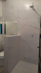Baño blanco con aseo y espejo en Casa Inteira Próxima ao Centro / 4 Suítes. en Londrina