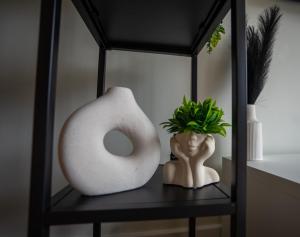 a black shelf with a white vase and a plant at Apple Tree in Redhill