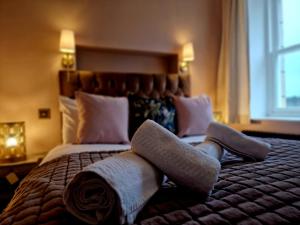 een slaapkamer met een groot bed en handdoeken bij Hamilton-The Alexander suite luxury holiday let's in Scorton
