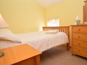 a bedroom with a bed and a dresser and a table at 2 Bed in Wroxham 29570 in Worstead