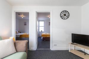 ein Wohnzimmer mit einem Sofa und einer Uhr an der Wand in der Unterkunft May Disc - Long Stay - Contractors in Bristol