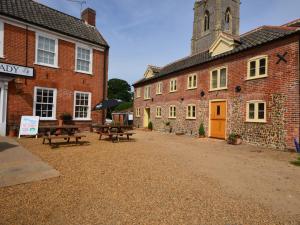 a courtyard of an old brick building with picnic tables at 2 Bed in Wroxham 29570 in Worstead