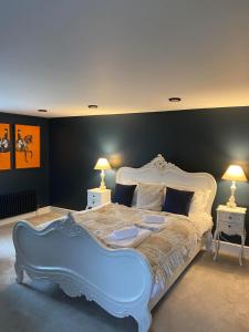 een groot wit bed in een kamer met 2 lampen bij Hamilton-The Alexander suite luxury holiday let's in Scorton