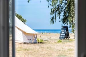 a tent and a sign on the beach at Nordliv Strand in Hasle