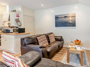 a living room with a leather couch and a table at 1 Bed in Perranporth THERO in Perranporth
