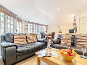 a living room with couches and a bowl of fruit on a table at 1 Bed in Perranporth THERO in Perranporth