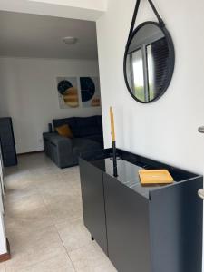 a living room with a mirror on the wall at Populo Beach Villa, Walk to Beach, Air Conditioning and Heating, near Ponta Delgada in Livramento