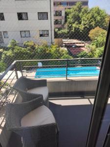 uma varanda com 2 cadeiras e uma piscina em Refugio IDEAL em Santiago