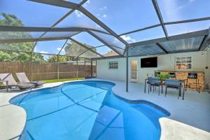 a patio with a swimming pool with a pergola at Backyard Oasis! 2 mi to Pier with Pool, Patio Bar & Putting Green in Safety Harbor