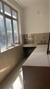 a kitchen with a counter and two windows at Occasions in Jammu