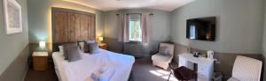 a bedroom with a bed and a sink and a television at Blazing Donkey Country Hotel in Sandwich