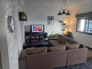 a living room with a couch and a tv at Sunset house in Soo