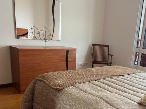 um quarto com uma cama, uma cómoda e um espelho em Populo Beach Villa em Livramento