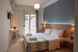 a bedroom with a bed and a table and a desk at Oliv Apartments in Platanes