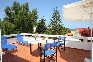 a patio with a table and chairs and an umbrella at Oliv Apartments in Platanes