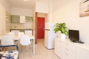 een keuken met een witte koelkast en een tafel en stoelen bij Park Residence 1 - Home Immobiliare in Lido di Jesolo