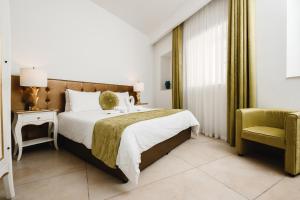 a hotel room with a bed and a chair at Giorgio Boutique Hotel in Sliema +87 photos