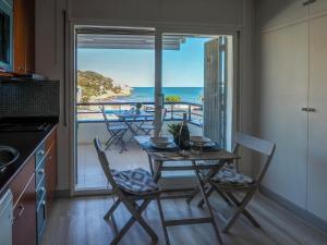 a kitchen with a table and chairs with a view of the ocean at The Beach Studio by Hello Homes Sitges in Sitges
