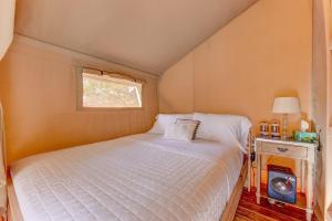 a small bedroom with a bed and a window at 12 Fires Luxury Glamping with AC #5 in Johnson City