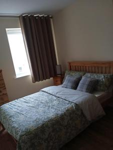 a bedroom with a large bed with a window at Highly Comfortable Home in Hatfield