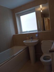 a bathroom with a sink and a toilet and a window at Highly Comfortable Home in Hatfield