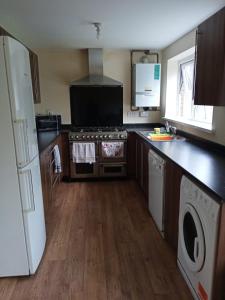 a kitchen with a stove and a washer and dryer at Highly Comfortable Home in Hatfield