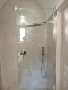 La salle de bains est pourvue d'une douche avec une porte en verre. dans l'établissement Dammusielenas, à Pantelleria