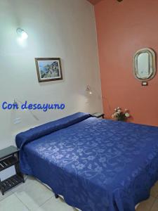 1 dormitorio con 1 cama con edredón azul en Fánsil en San Juan