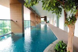 a large swimming pool in a building with blue water at Apt Capitol Suite Senen 2 BR with Pool & Wifi in Jakarta