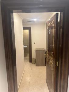 a bathroom with a door leading to a bathroom with a toilet at مشارق مني in Al ‘Azīzīyah
