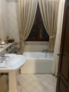 La salle de bains est pourvue d'une baignoire et d'un lavabo. dans l'établissement Villa Silvia, à Alliste