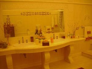 La salle de bains est pourvue de 2 lavabos et d'un grand miroir. dans l'établissement Villa Silvia, à Alliste