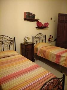 1 dormitorio con 2 camas, mesa y estante en Villa Silvia, en Alliste
