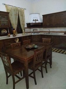 cocina con mesa de madera y sillas de madera en Villa Silvia, en Alliste