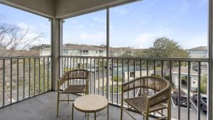 2 sillas y una mesa en un balcón con vistas a un aparcamiento en Landing Modern Apartment with Amazing Amenities (ID1403X079), en Pinellas Park