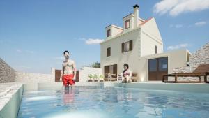 Ein Mann steht am Rande eines Schwimmbads neben einem Haus. in der Unterkunft Villa on Biševo - transfer and car included, 5 min to the sea in Polje