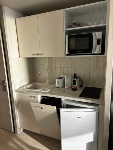 een keuken met witte kasten en een magnetron bij Villa Francia Cannes in Cannes