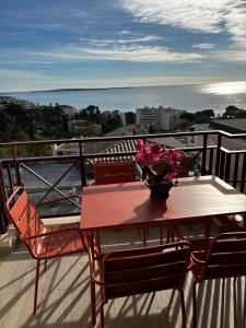 een tafel met een vaas met bloemen op een balkon bij Villa Francia Cannes in Cannes