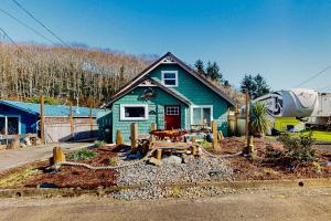 una casa verde con una mesa de picnic delante de ella en The Cozy Crab Cottage, en Reedsport